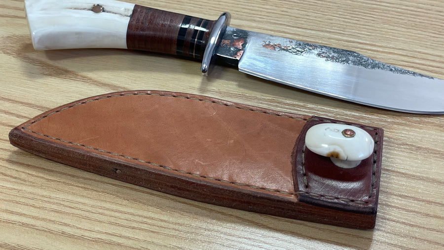 Cuchillo forjado  “Cowboy Bowie” de Nil Fonsere, con cuero, colmillo de facochero y gemelo a conjunto